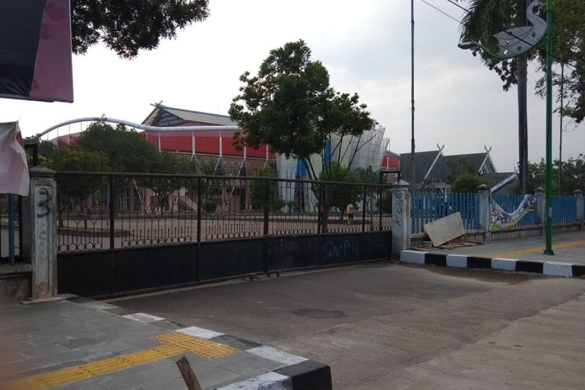 Gerbang GOR Kota Baru digembok, pelari pagi parkir kendaraan di pinggir jalan