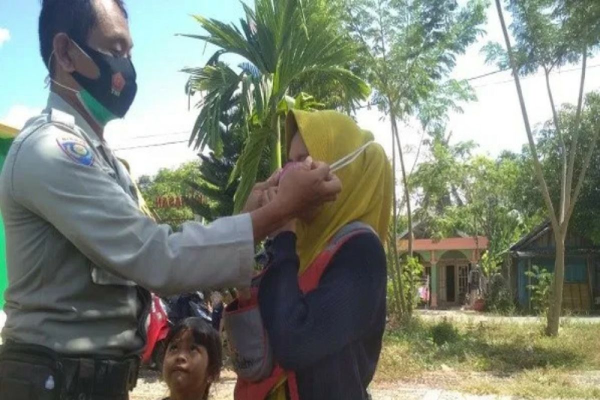 Bhabinkamtibmas bagikan masker ke warga