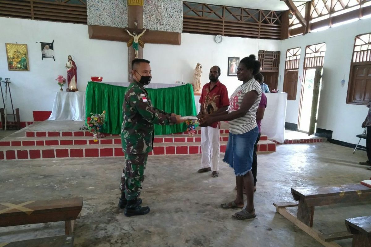 Prajurit TNI Satgas Yonif 125/Si'mbisa bagikan alkitab ke jemaat gereja