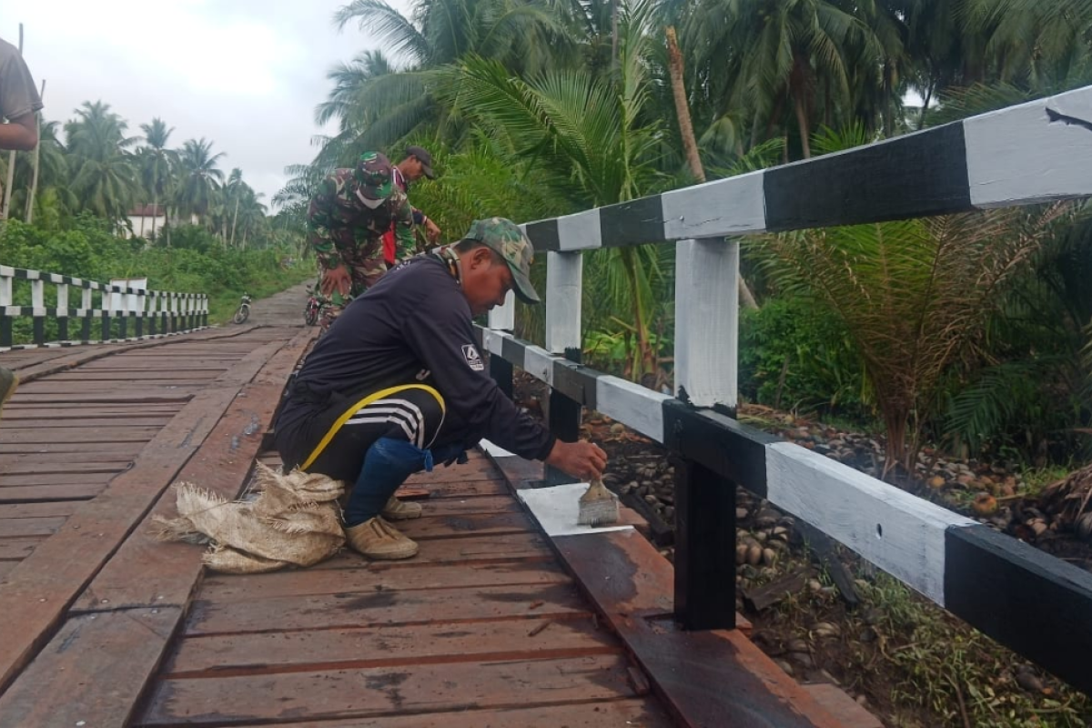 Warga dan TNI mulai mengecat pagar Jembatan Handil Samsu
