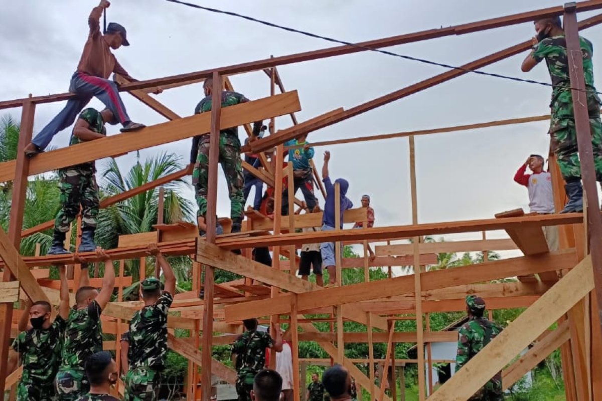 Satgas TMMD dan warga pemasangan kuda-kuda bagunan Pos Terpadu