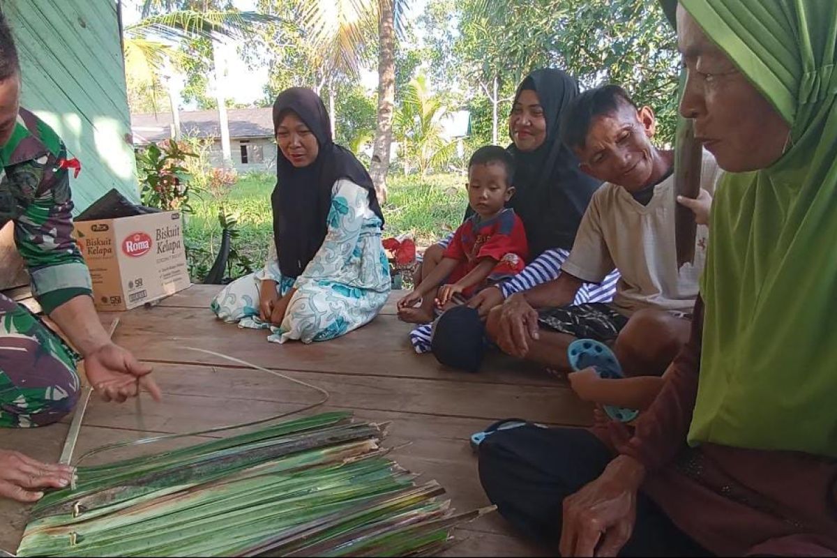 Anggota Satgas TMMD belajar anyam atap berbahan daun