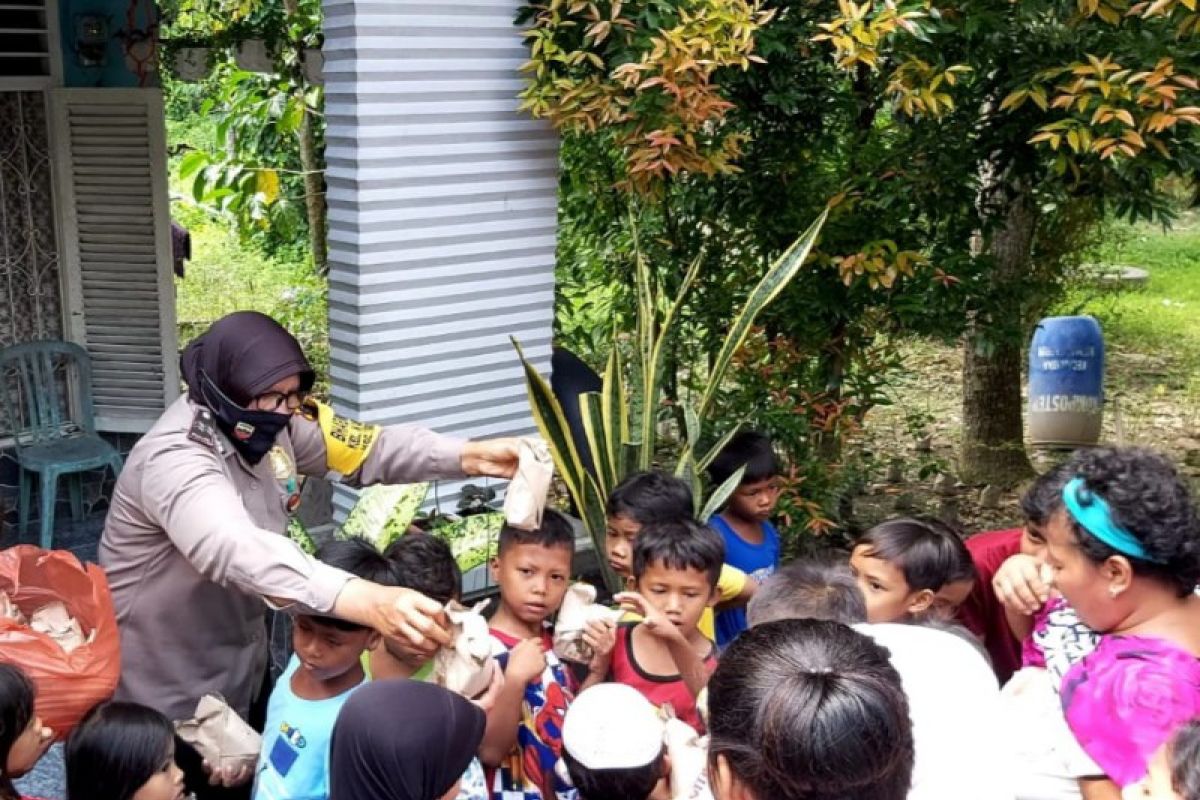 Polsek Medan Kota  berbagi kasih dengan warga bantaran sungai