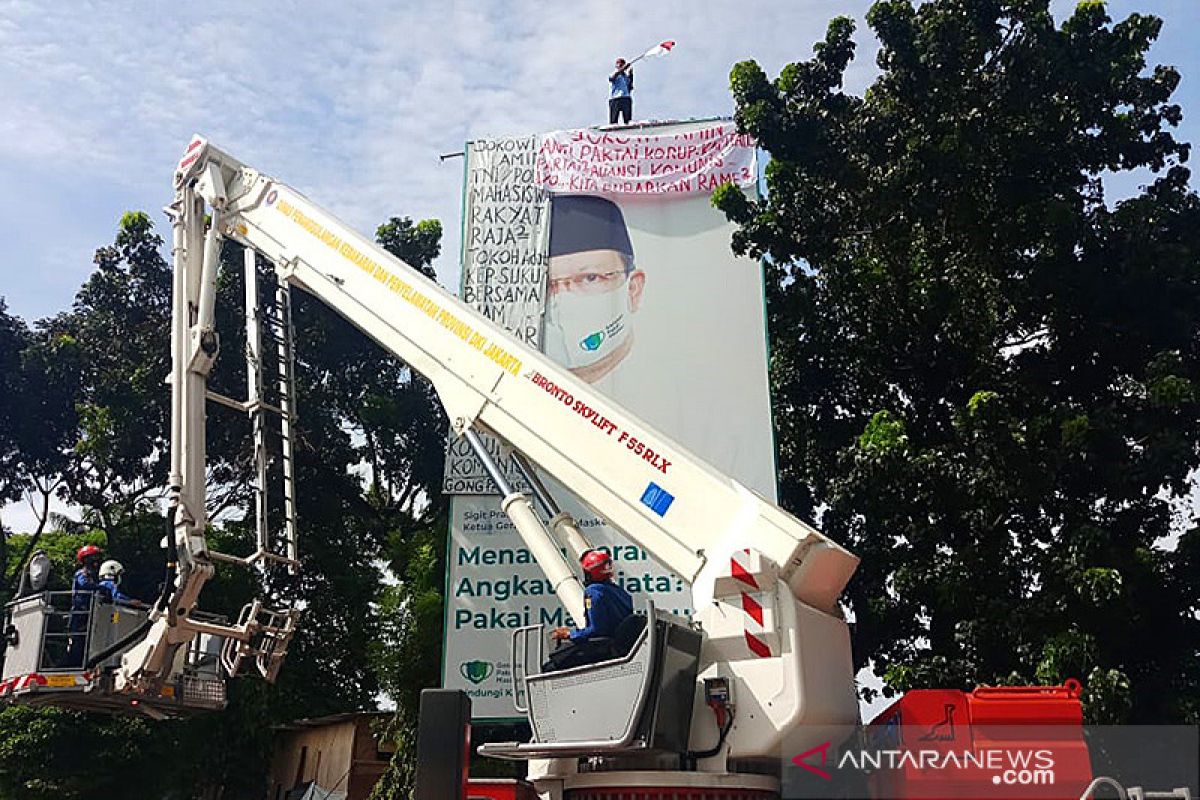 Panjat reklame, Agustinus Woro juga bawa sebotol bensin