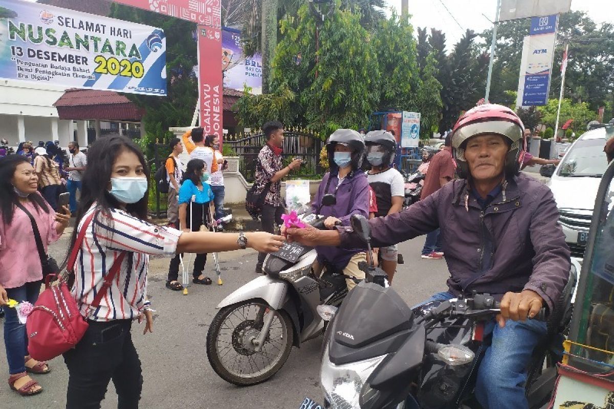 Penyandang disabilitas bagi bunga  kepada warga Pematangsiantar