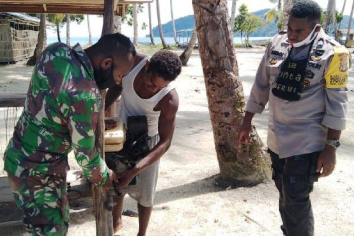 Babinsa-Bhabinkamtibmas bantu perbaiki mesin perahu warga di kampung Yenusi