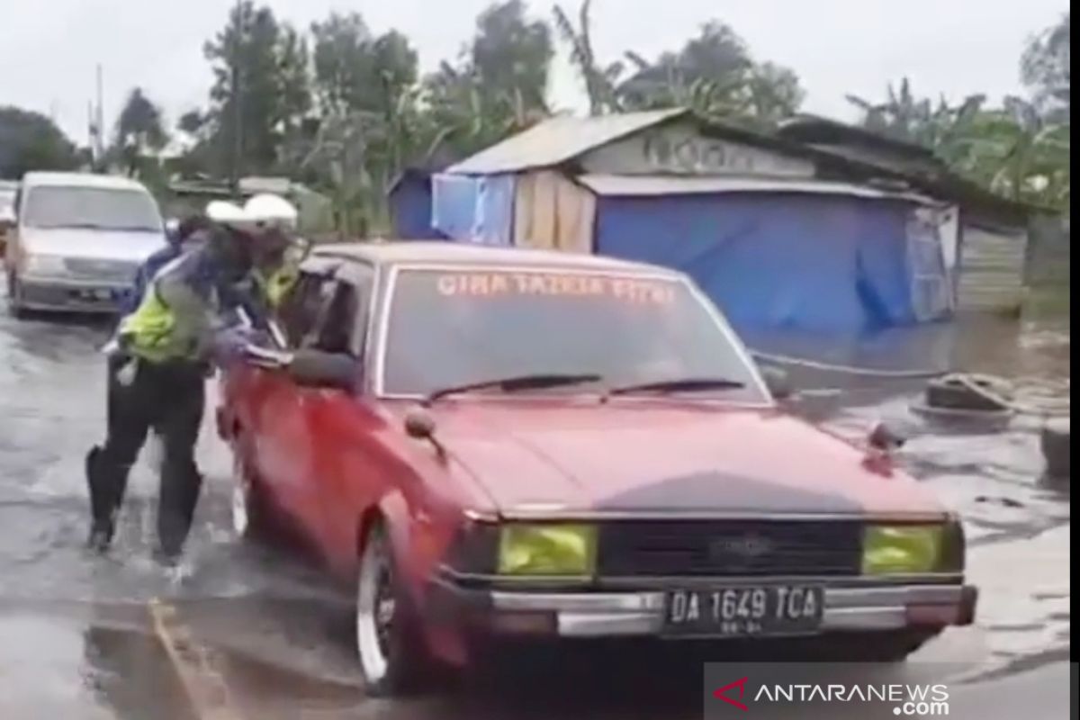 Polres Tanah Laut membantu pengendara terjebak banjir di Gunung Raja