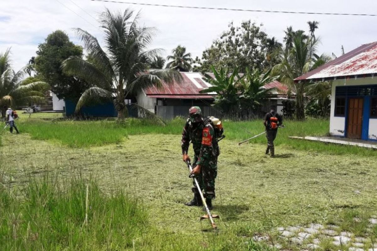 Babinsa Koramil Warbah bersihkan lingkungan perkarangan balai kampung