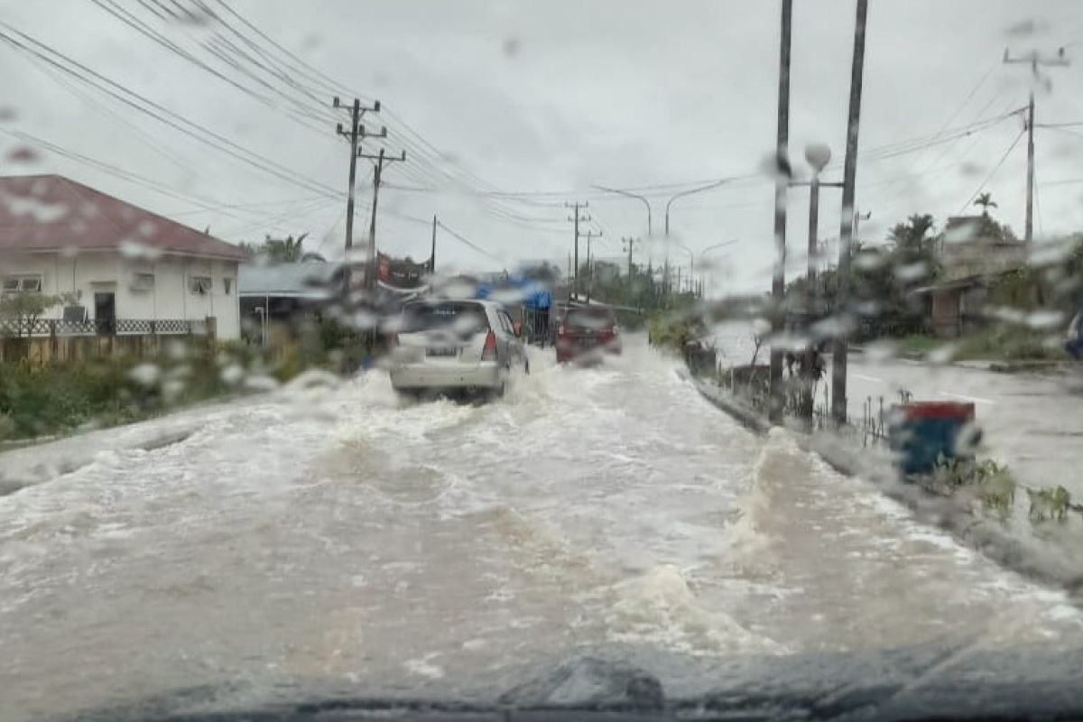 Kendaraan berpacu menembus genangan air di jalan utama Kualatungkal