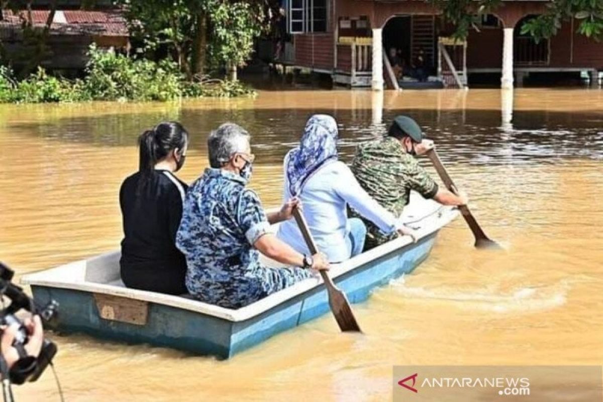 Raja Malaysia tinjau lokasi banjir dengan sampan