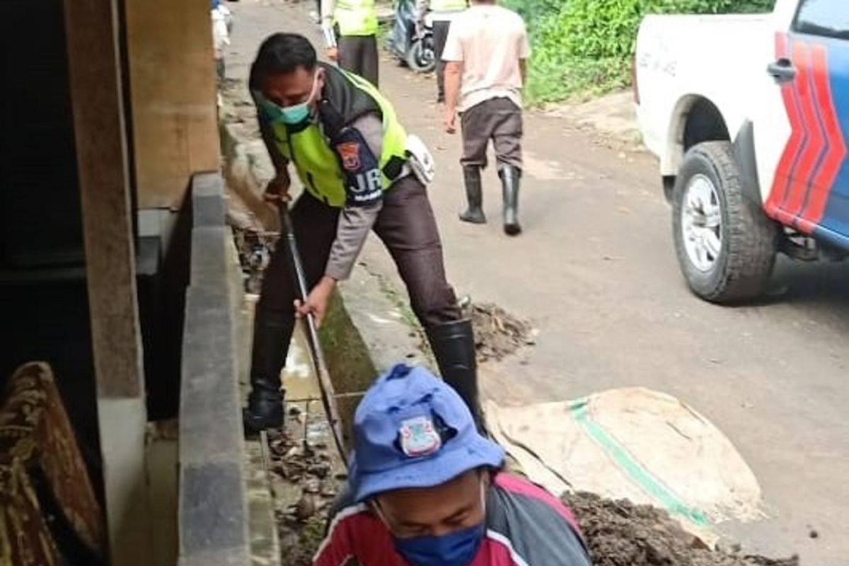 Personel Polantas Polda Sulut bantu warga bersihkan material banjir Manado