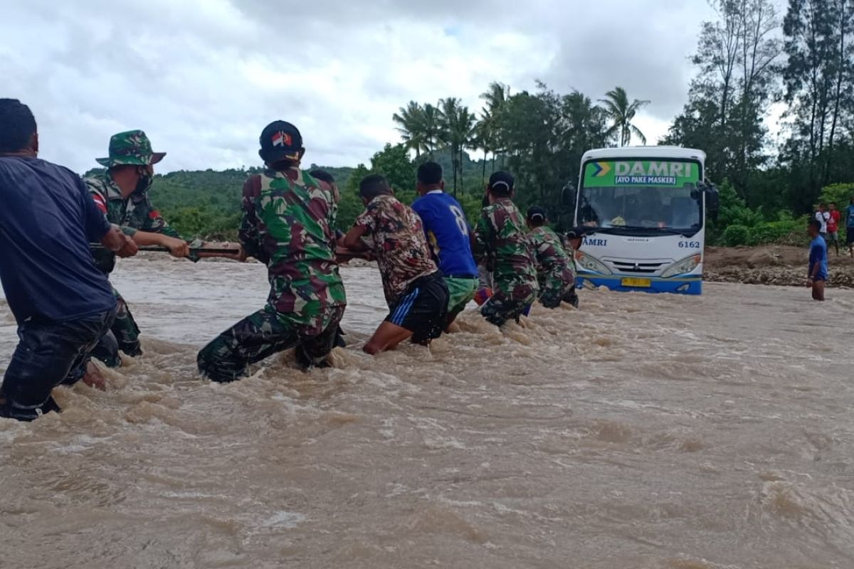 Satgas Yonarmed bantu warga seberangi jalan putus akibat  banjir di TTU