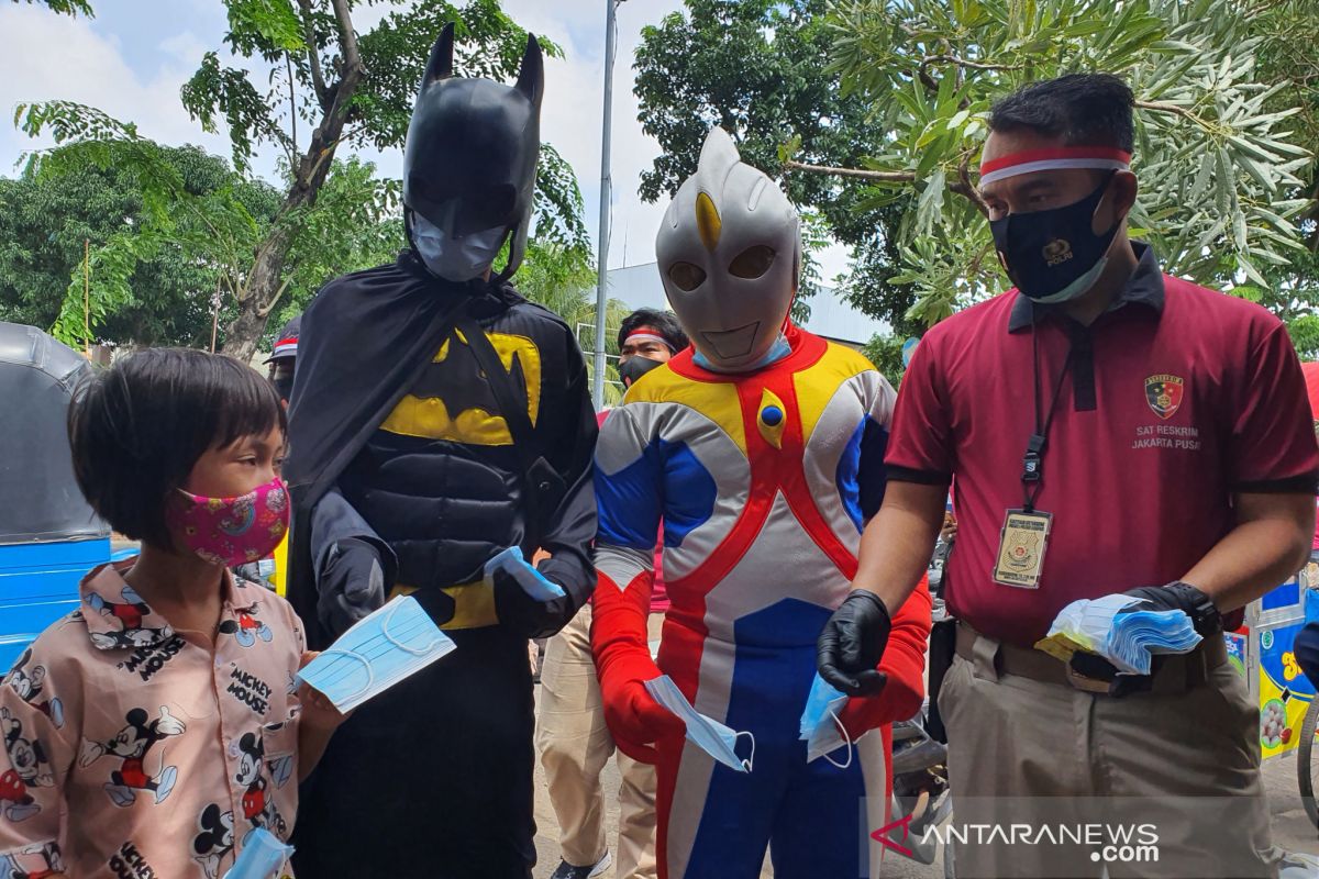 Ultraman dan Batman bagikan masker bersama Satreskrim Jakpus di Senen