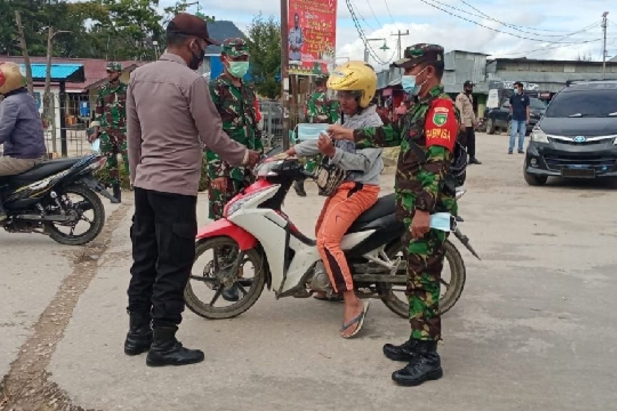 Personel TNI-Polri bagi masker ke warga Enarotali Paniai