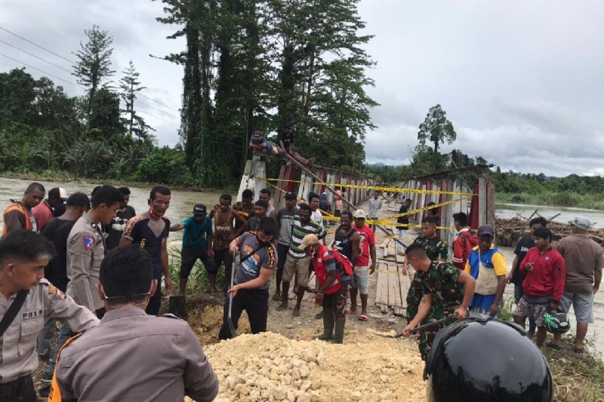 Soldiers, policemen, locals repair bridge near RI-PNG border