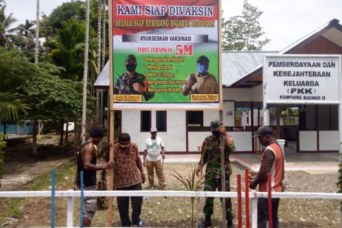 Babinsa Koramil Yapsel bersama warga Kampung Kainui II pasang banner siap divaksin