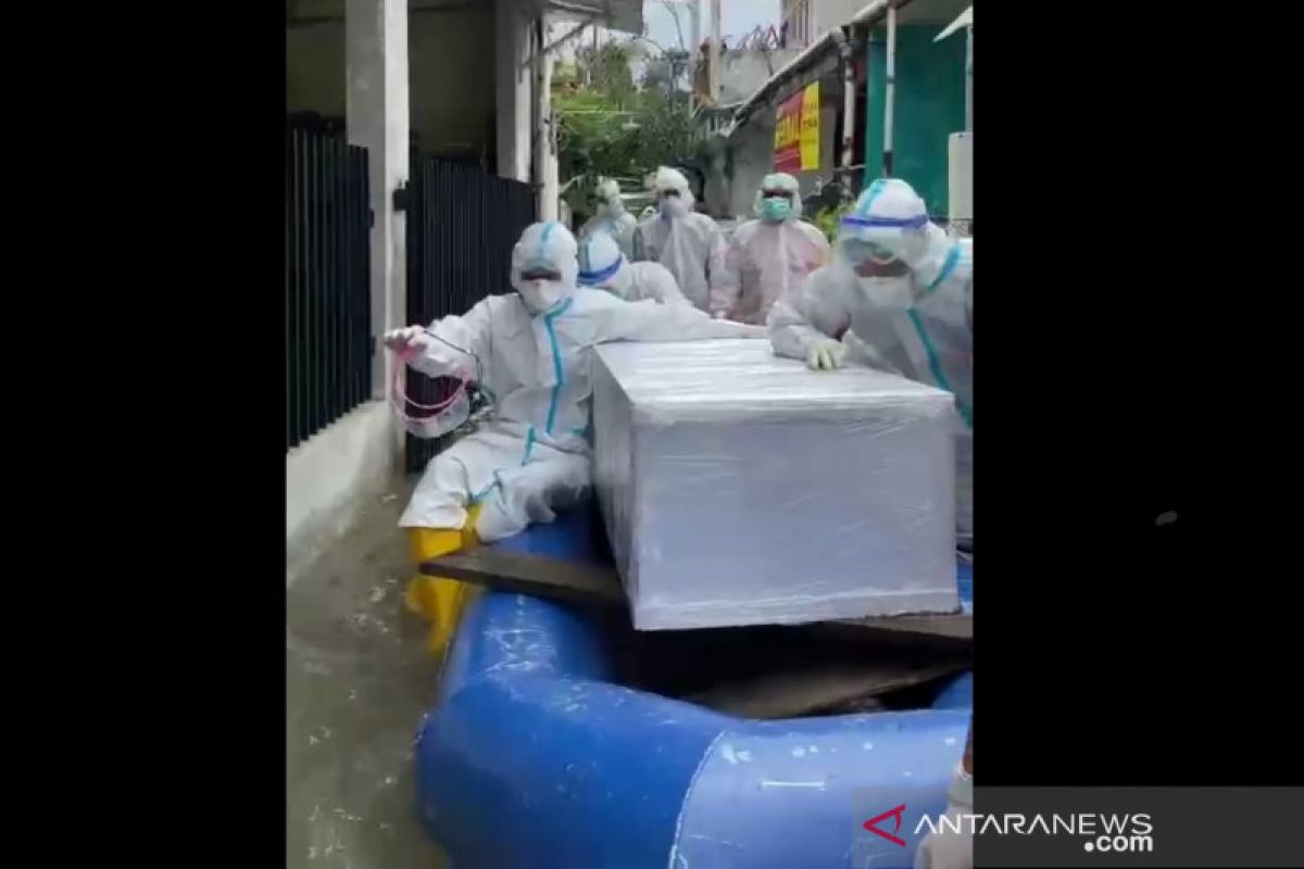 Di tengah kepungan banjir, tim Polda Metro Jaya evakuasi jenazah COVID-19