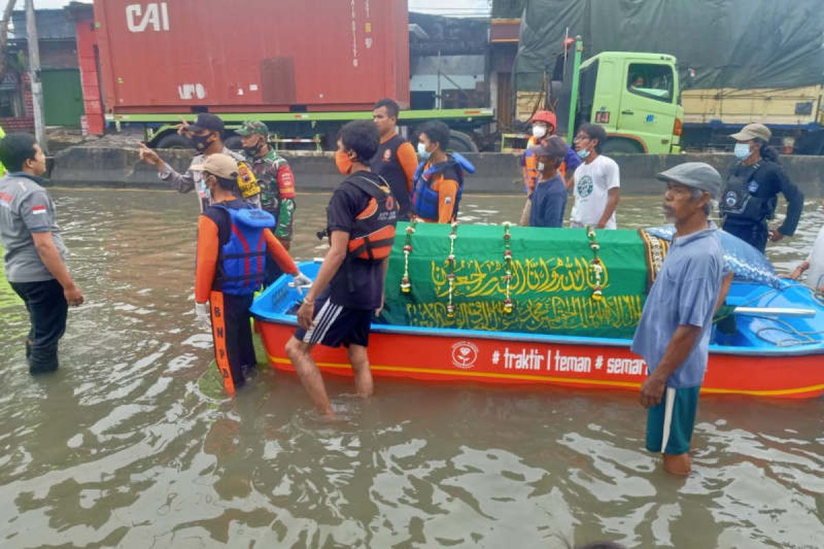 Petugas bawa jenazah pakai perahu di tengah banjir untuk dimakamkan