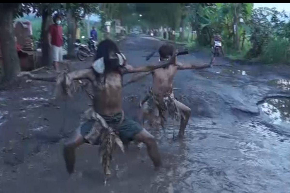 Seniman gelar seni parodi di jalan rusak