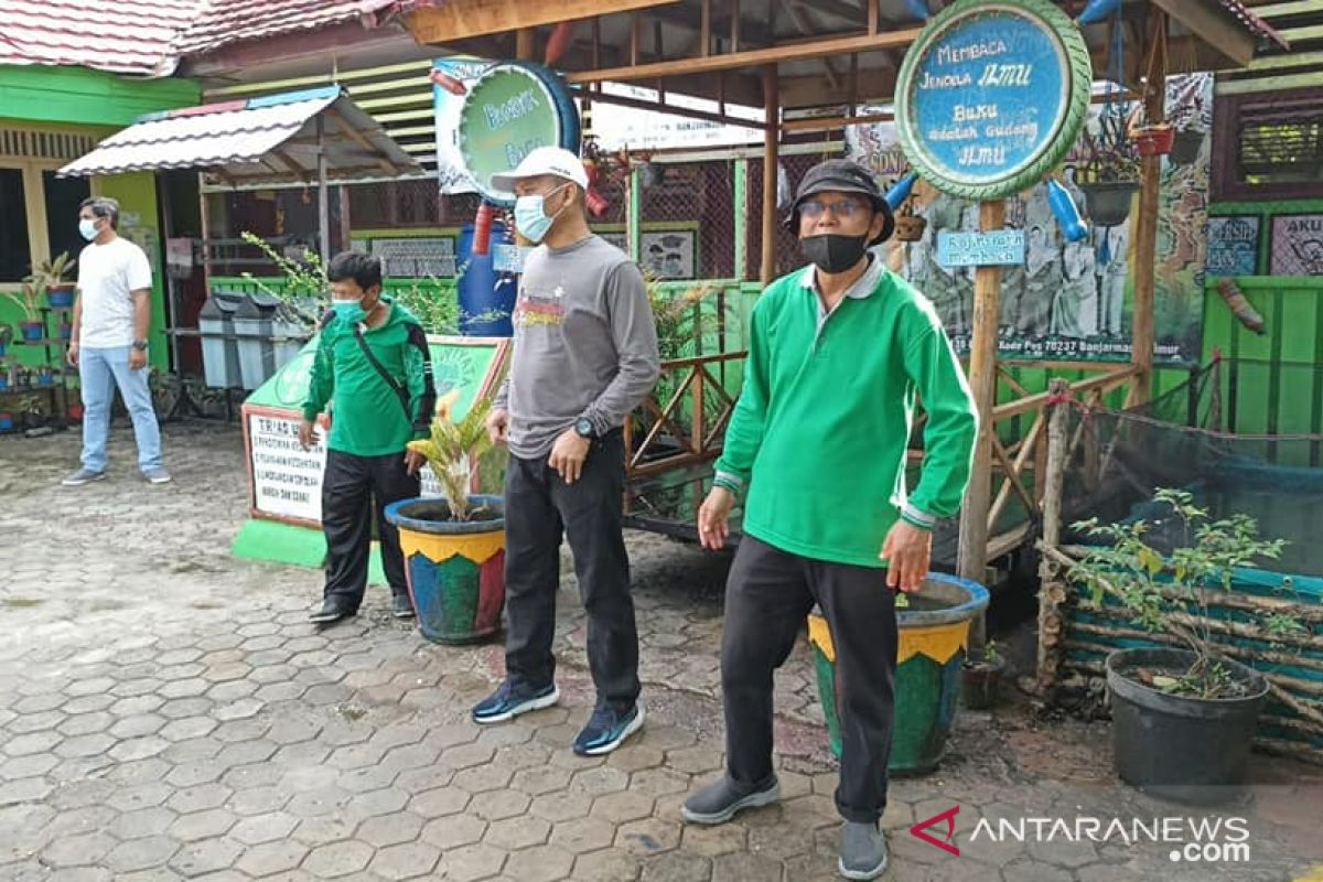 Hijau Daun greens and cleans schools after flood