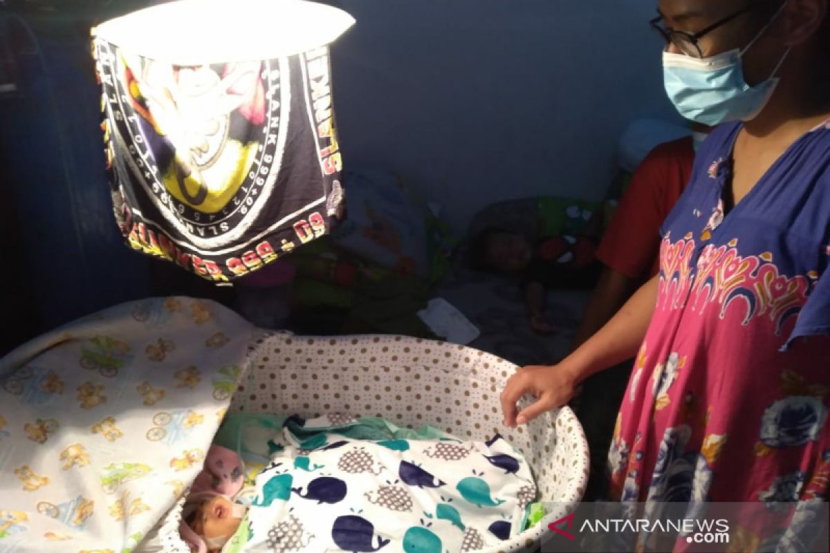 Dengan bantuan mesin oksigen bayi tanpa tempurung kepala masih bertahan di rumahnya