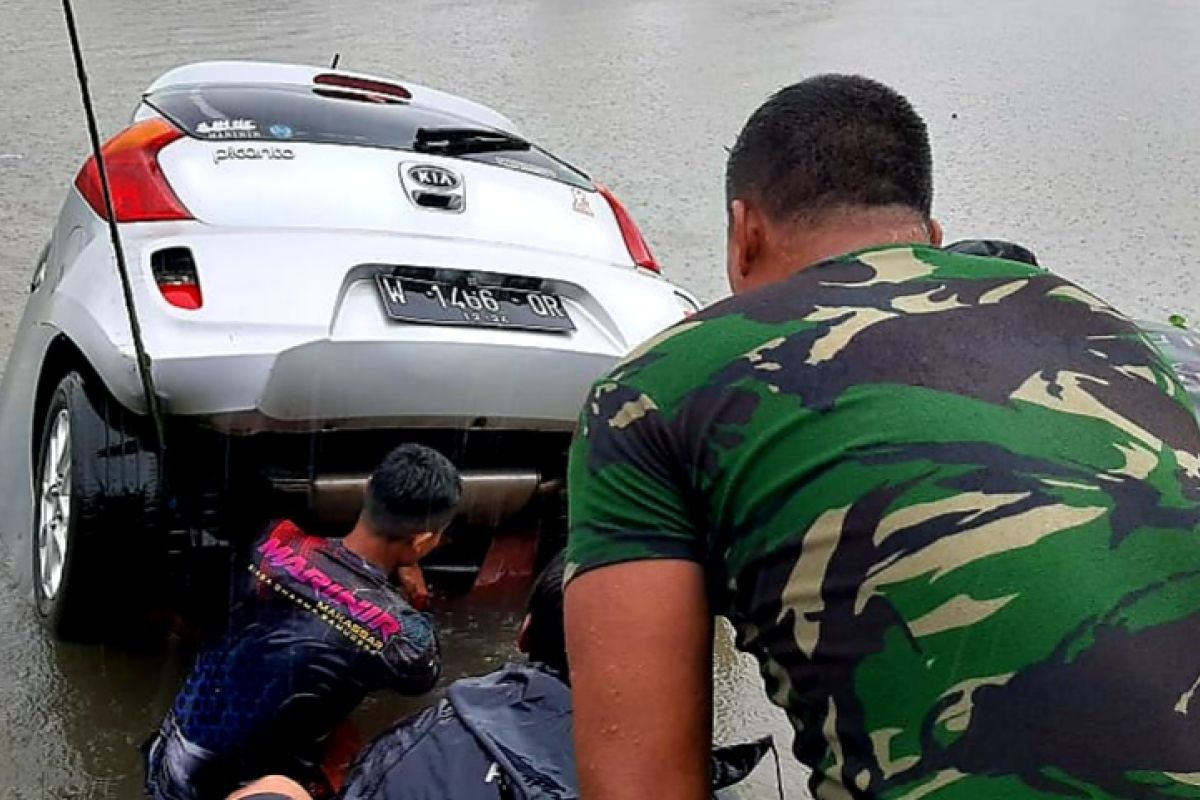 Marinir TNI AL mengevakuasi mobil yang tenggelam di kanal saat banjir