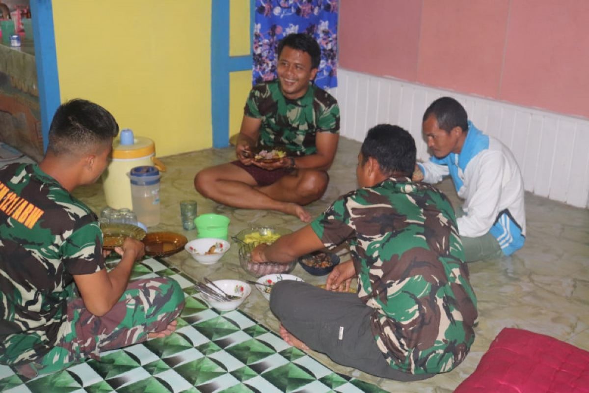 Anggota Satgas TMMD makan malam di rumah warga