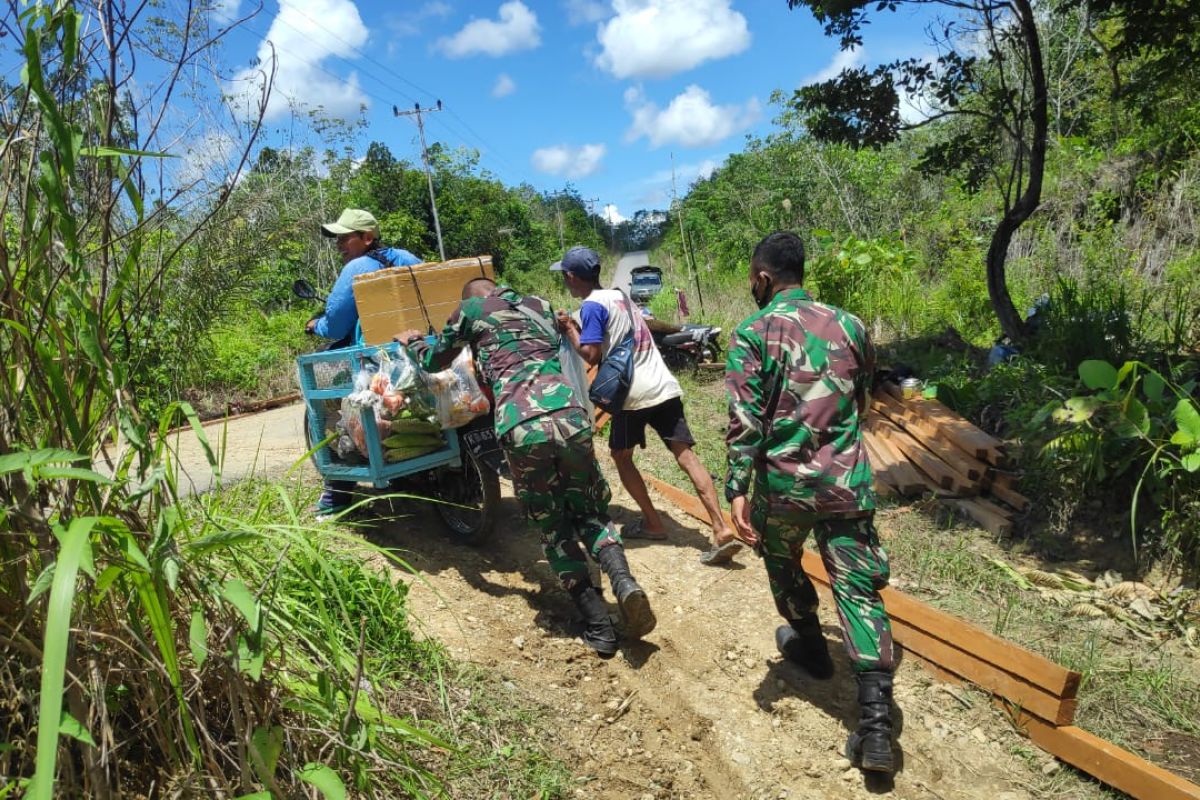 Anggota TMMD Regtas ke-110 bantu dorong sepeda motor penjual sayur di tanjakan