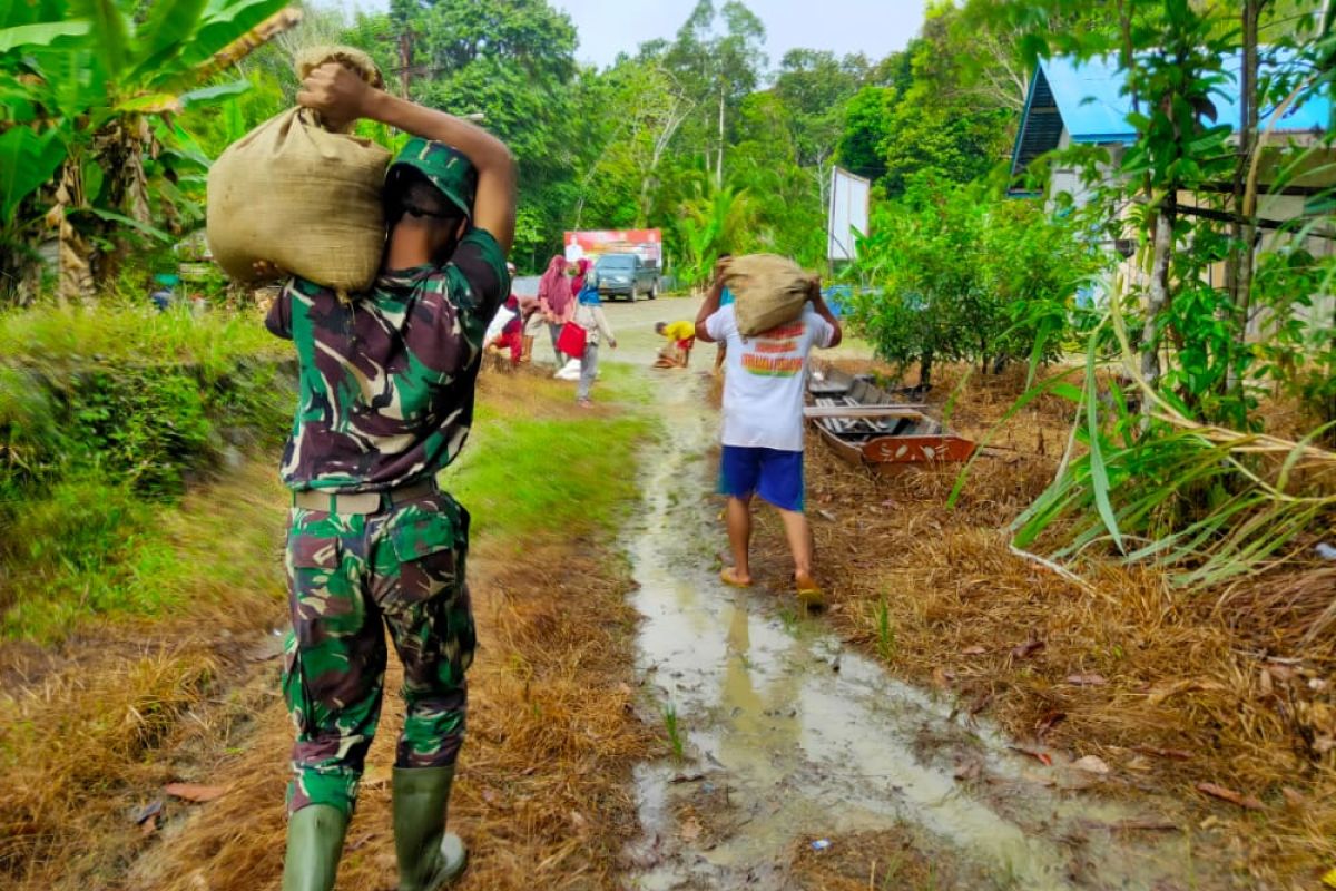 Anggota Satgas TMMD dan warga bersemboyan berat sama dipikul