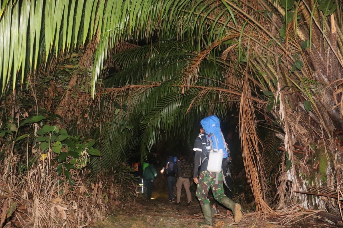 Anggota TMMD bersama warga Tintin Kemantan daki bukit Datuk