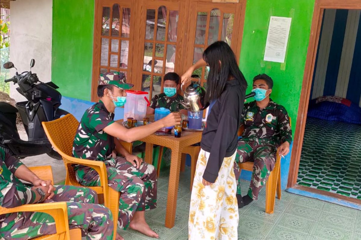 Dengan senyuman, remaja putri tuangkan kopi ke gelas Personil TMMD