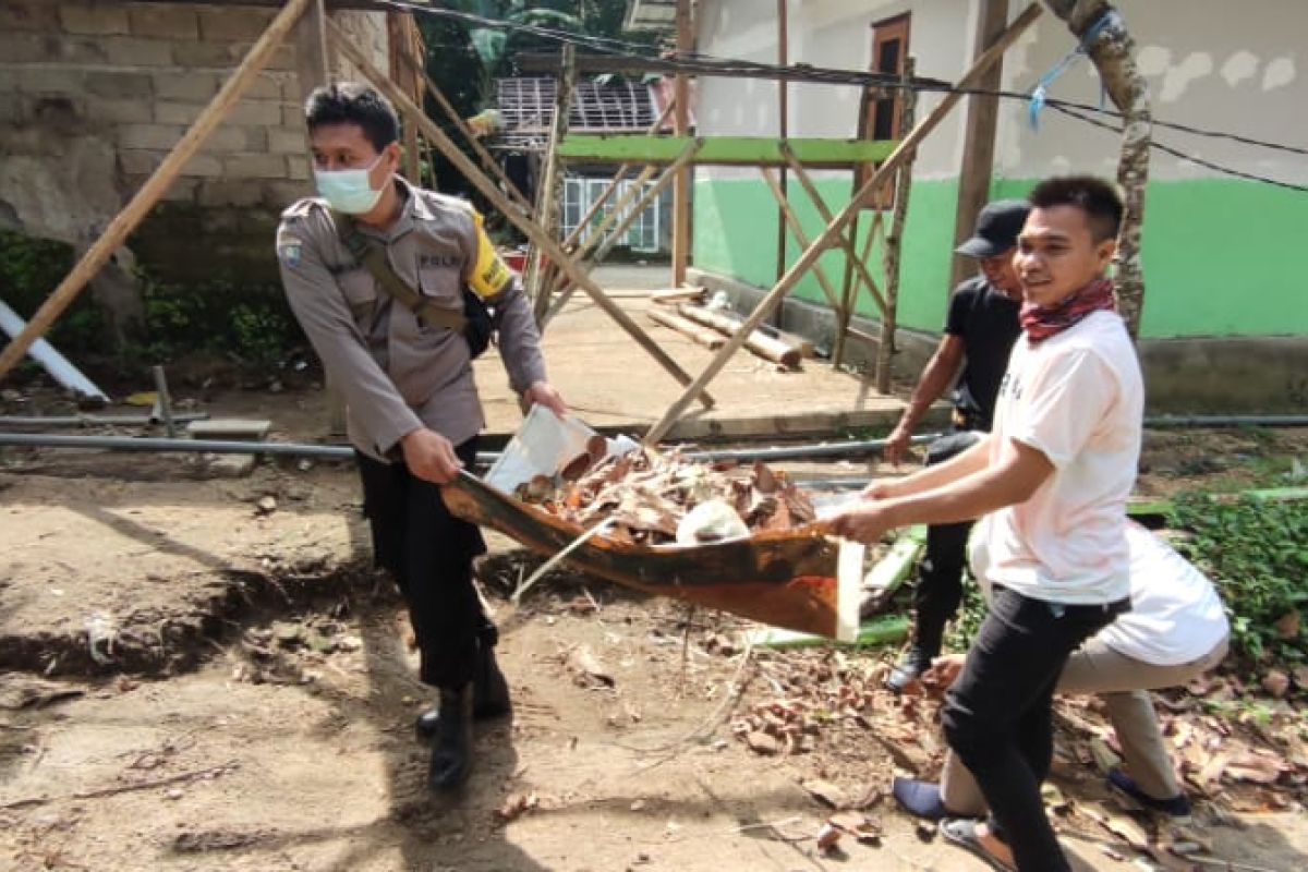 Bhabinkamtibmas Taman Sari gotong royong bersihkan sampah dan bekas material bangunan