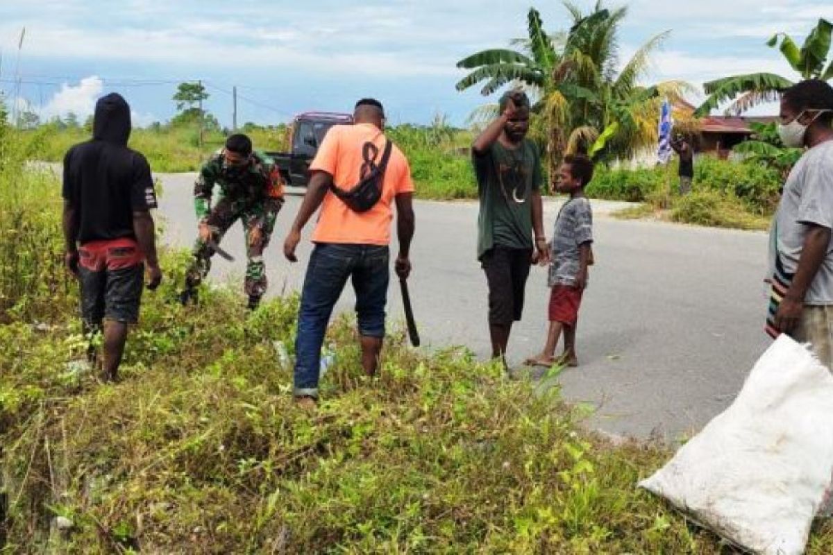 Babinsa Koramil Timika dan warga kelurahan Kamoro Jaya bersihkan jalan