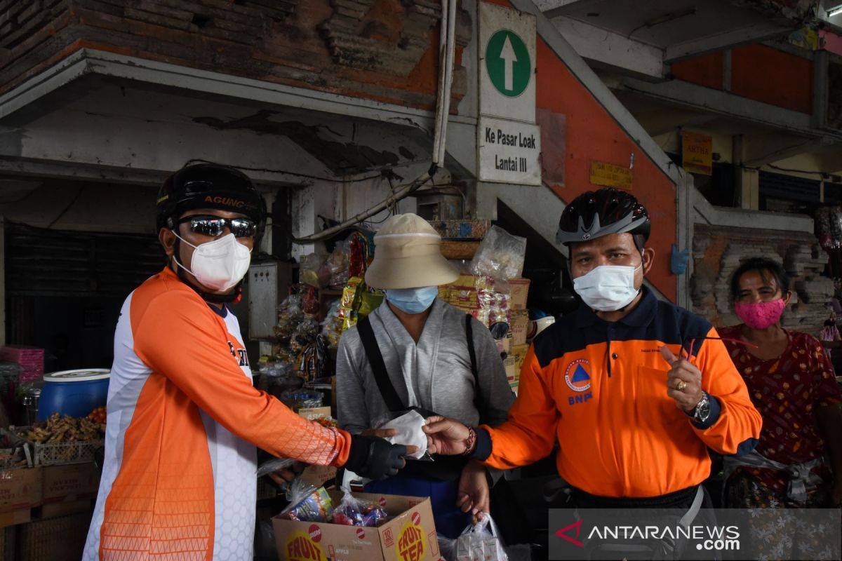 KPU Bali dan BPBD bersepeda bagikan masker ke pedagang pasar