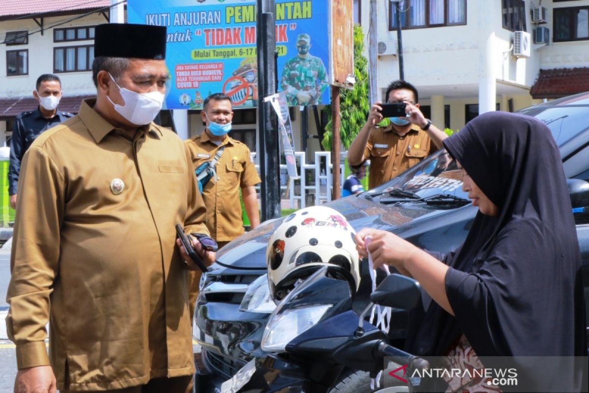 Dalam terik matahari, Bupati dan isteri bagi-bagi masker untuk warga di jalan raya