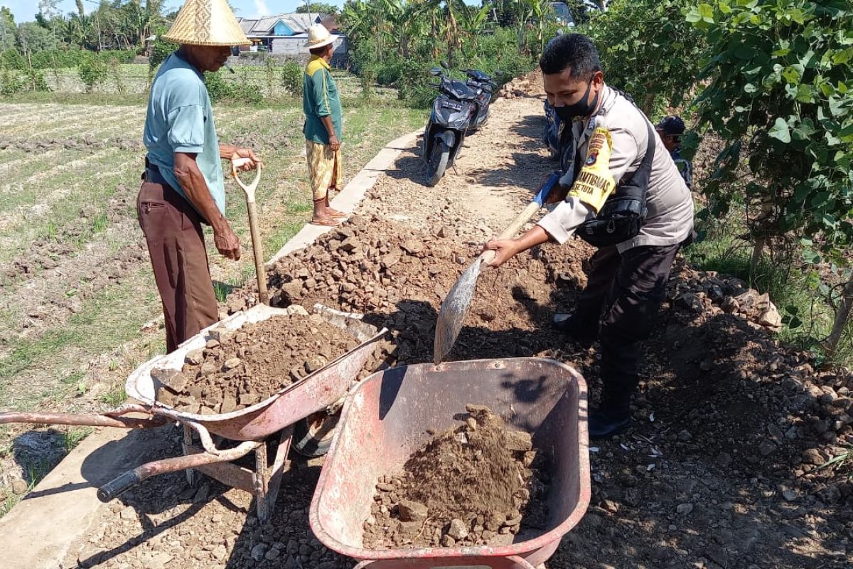 Bhabinkamtibmas Desa Setuta bantu warga timbun jalan