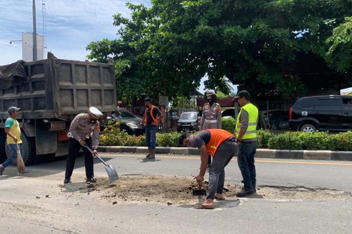 Cegah kecelakaan, polisi lalu lintas tambal jalan berlubang