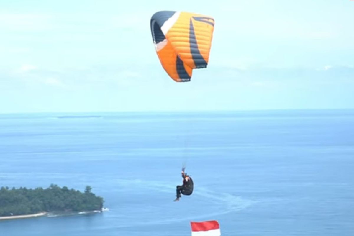 Polda Sumbar bersama Lanud Sutan Sjahrir kibarkan bendera di udara Kota Padang dengan paralayang