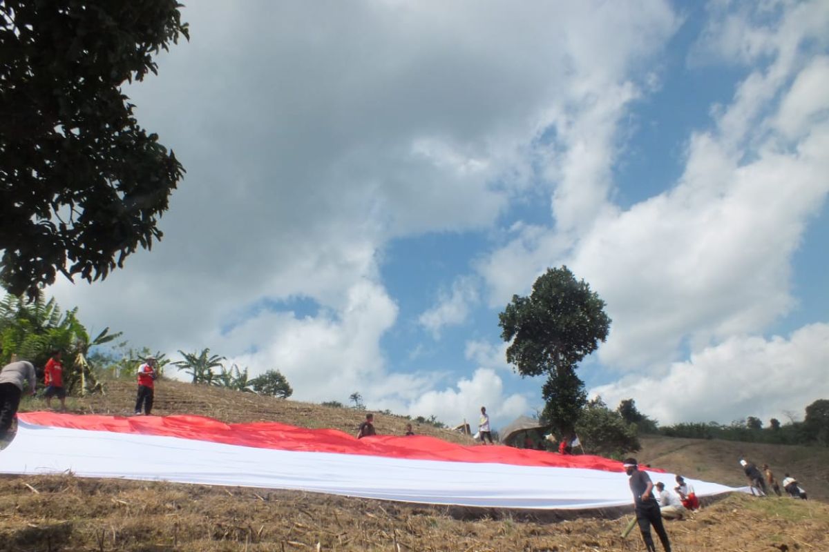Warga Desa Lampeji Jember mengibarkan bendera merah putih raksasa