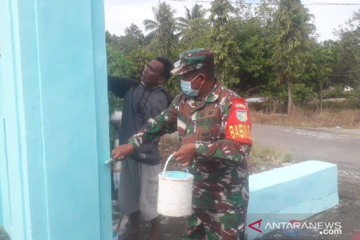 Aparat TNI bersama warga Nabire pengecatan gapura