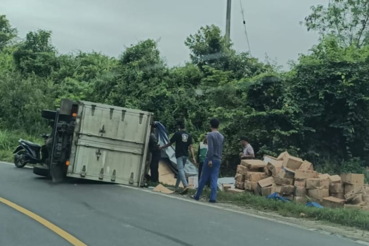 Mobil box terguling di tikungan, dus muatanya tumpah