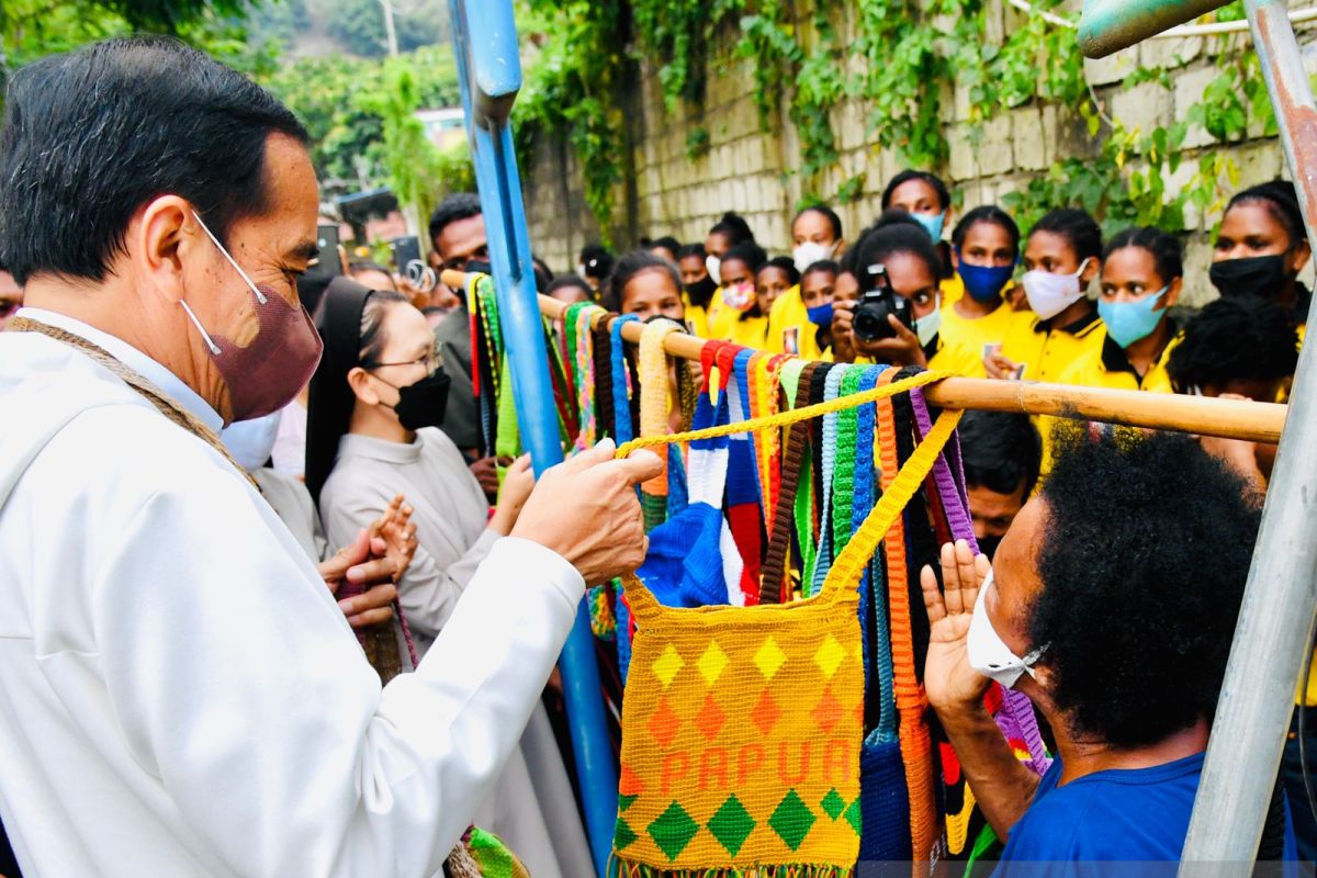 After arriving at Sentani airport, President stops to buy noken