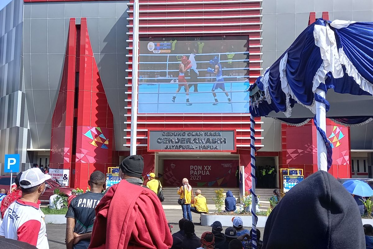 PON Papua - Warga Papua antusias menonton pertandingan tinju melalui layar lebar