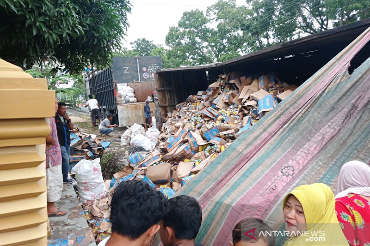 Truk tronton bermuatan minuman terbalik di depan Yonif 111