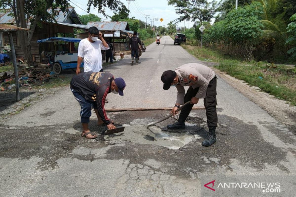 Cegah lakalantas, Bhabinkamtibmas bersama RCommunity perbaiki jalan berlubang