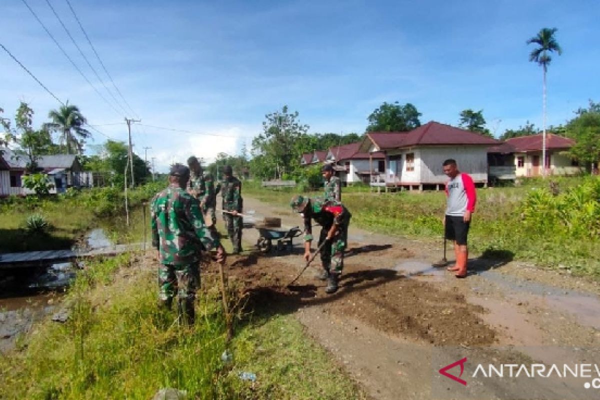 TNI bersama warga Mimika kerja bakti timbun jalan berlubang