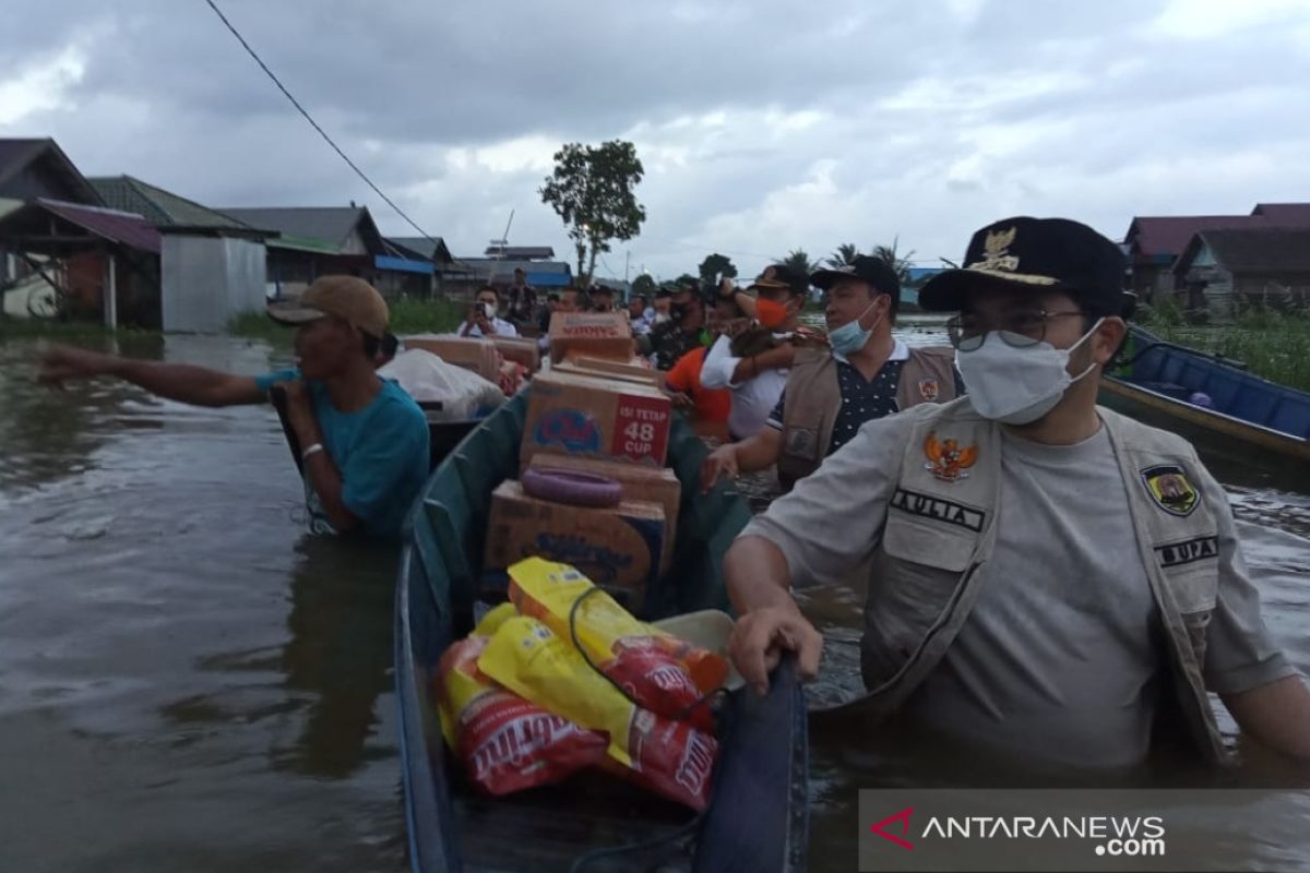 Transportasi ke Desa Pahalatan yang masih banjir hanya bisa menggunakan jukung