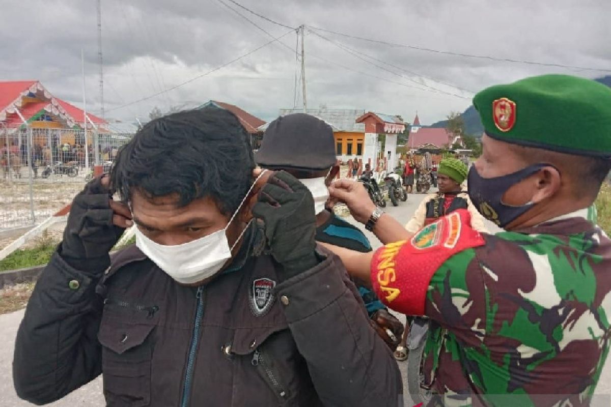 Aparat TNI bagikan masker ke warga pengguna jalan di Tigi Deiyai