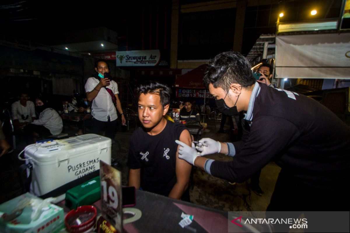 Beberapa warga mengikuti "vaksin on the road" malam tahun baru