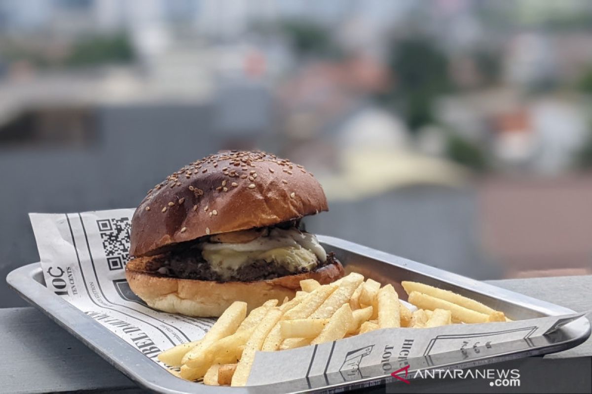 Makan burger truffle dikelilingi dengan pemandangan gedung pencakar langit